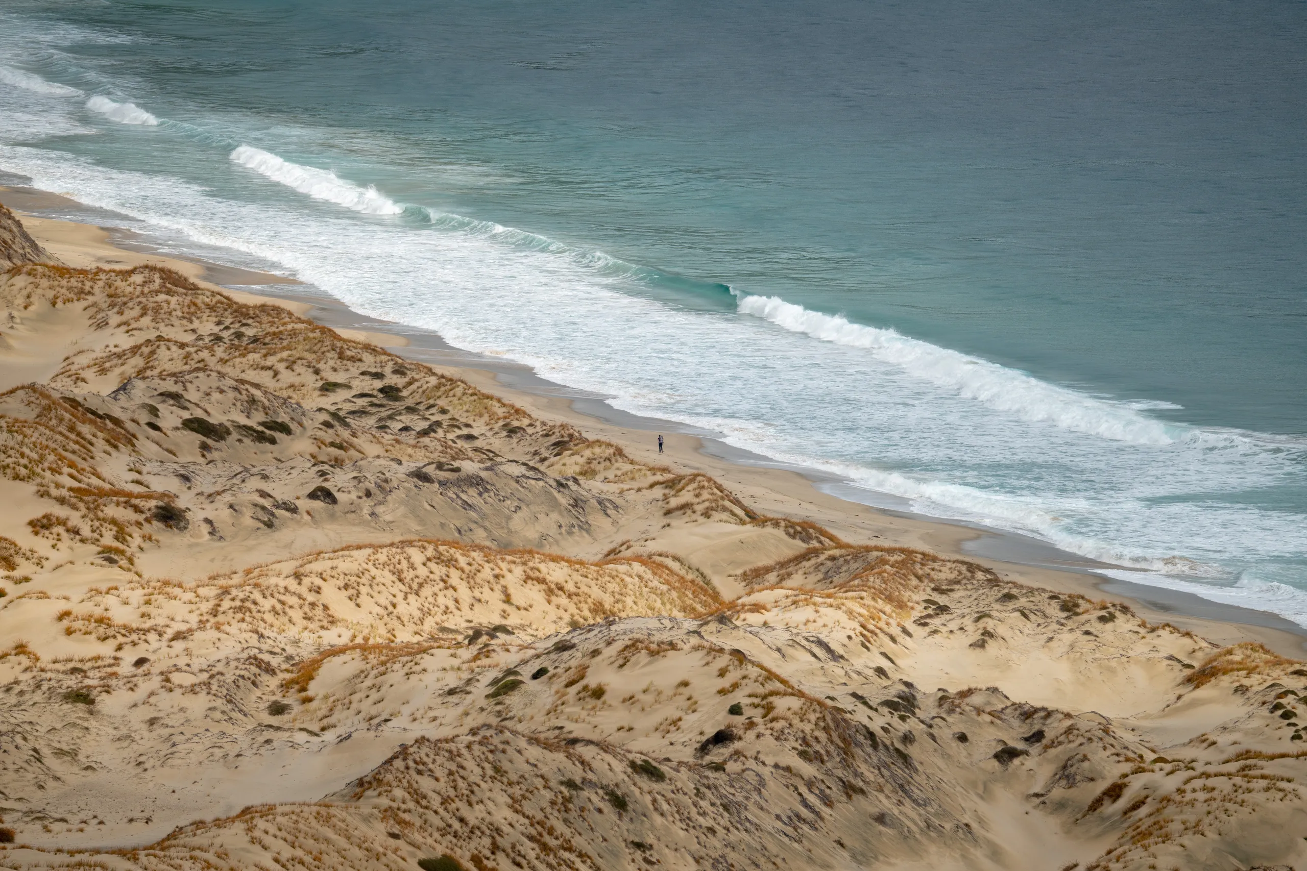 Solo hiker crossing Smoky Beach